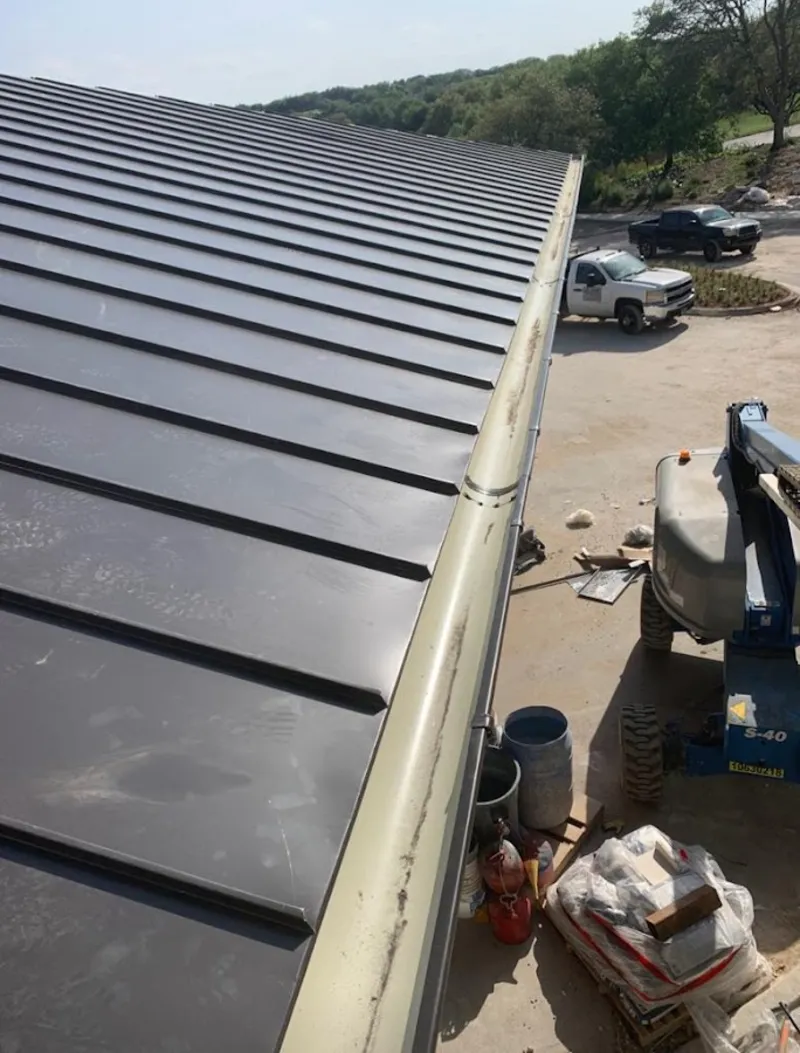 Standing seam panel and gutter detail on a metal roofing jobsite in Torrington
